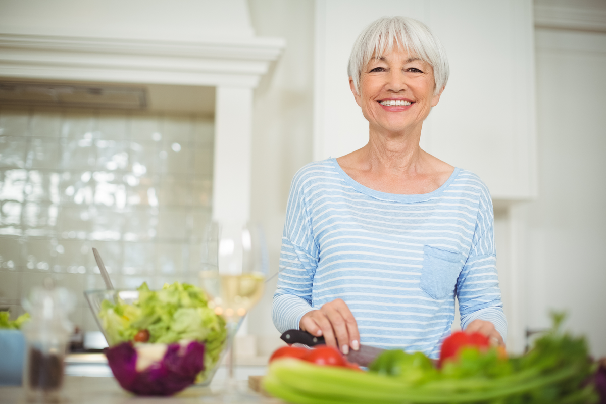 Senior woman preparing vegetable salad